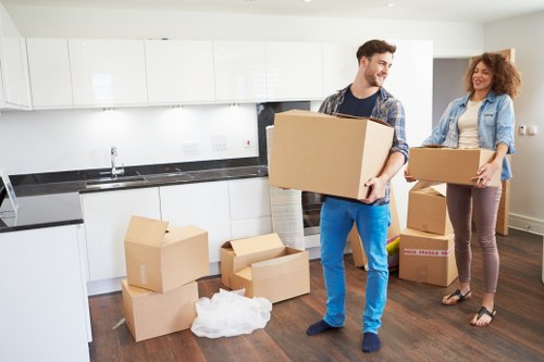 Specialist movers handling a piano outside a Bow apartment building